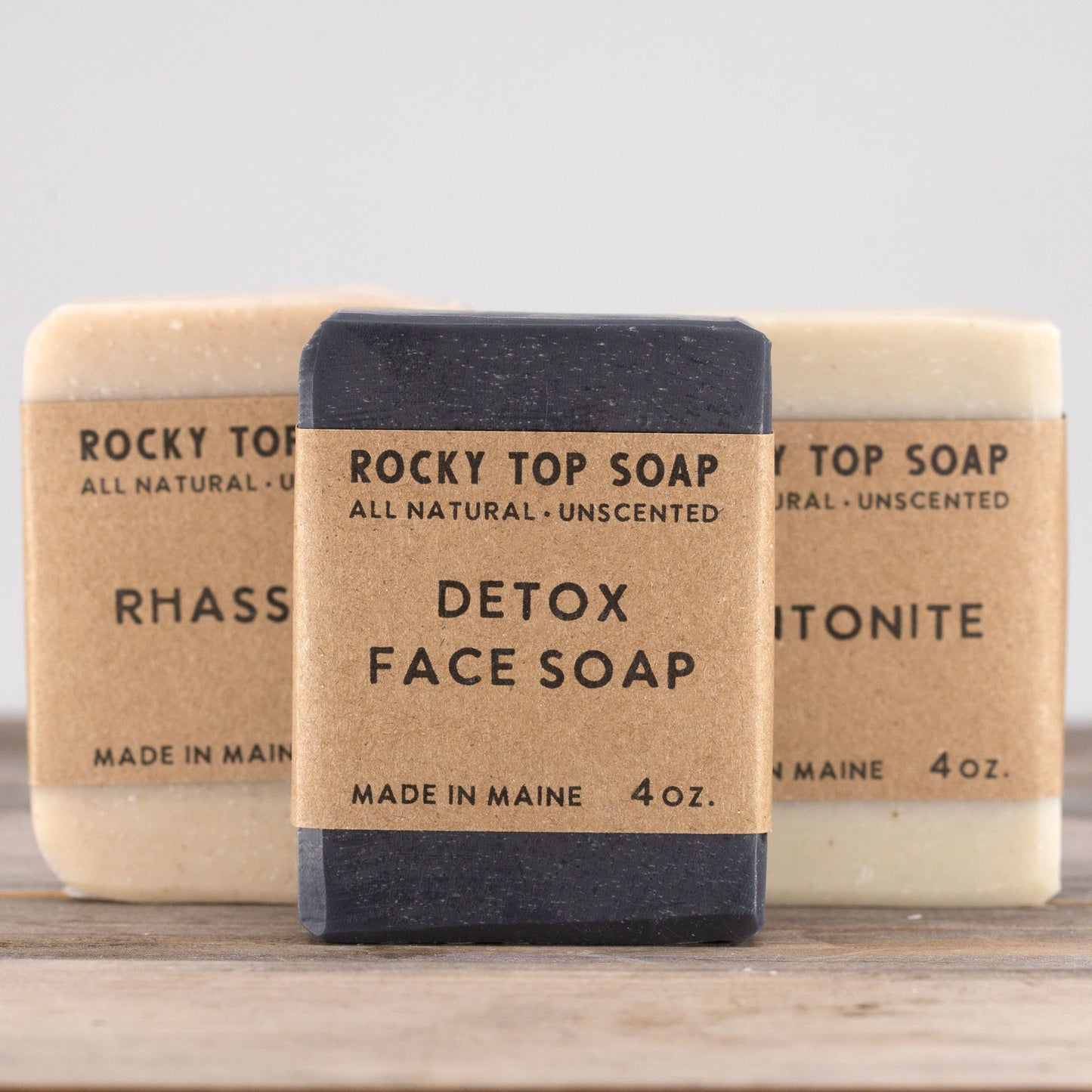 Clay Soap Set with Rhassoul and Bentonite Clay bars, wrapped in kraft bands, arranged on weathered wood boards from rockytopsoap.com, an unscented handmade detox soap collection.