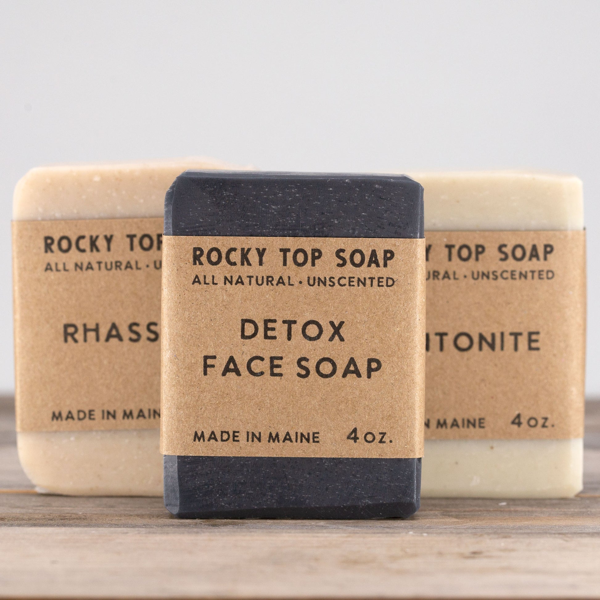 Clay Soap Set with Rhassoul and Bentonite Clay bars, wrapped in kraft bands, arranged on weathered wood boards from rockytopsoap.com, an unscented handmade detox soap collection.